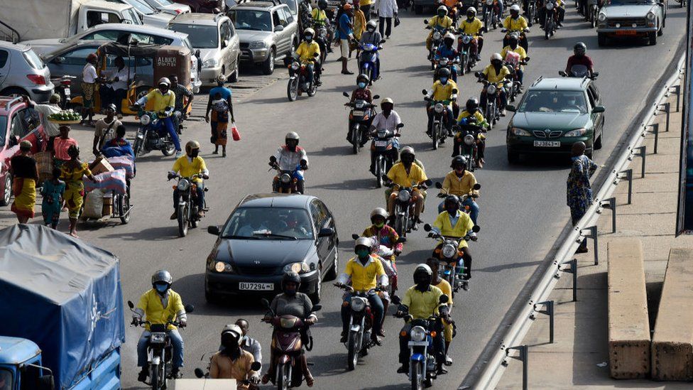 People ride in motorbike taxis popularly called Zemidjan in Cotonou on April 7, 2021.