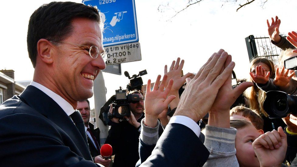 Mark Rutte high fives children after casting his vote in the Dutch general election