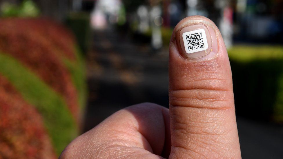 A sticker displaying a QR code is seen attached to a fingernail in the city of Iruma, a western suburb of Tokyo, 5 December 2016