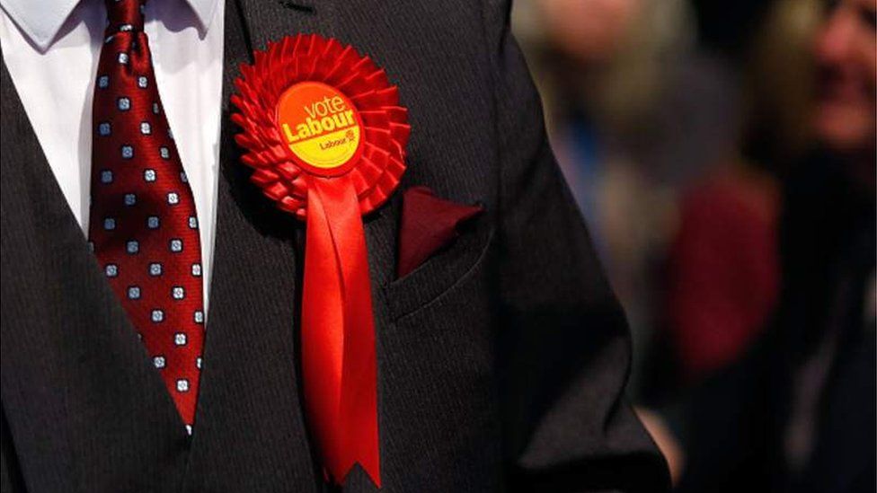 Man in suit wearing a Labour rosette
