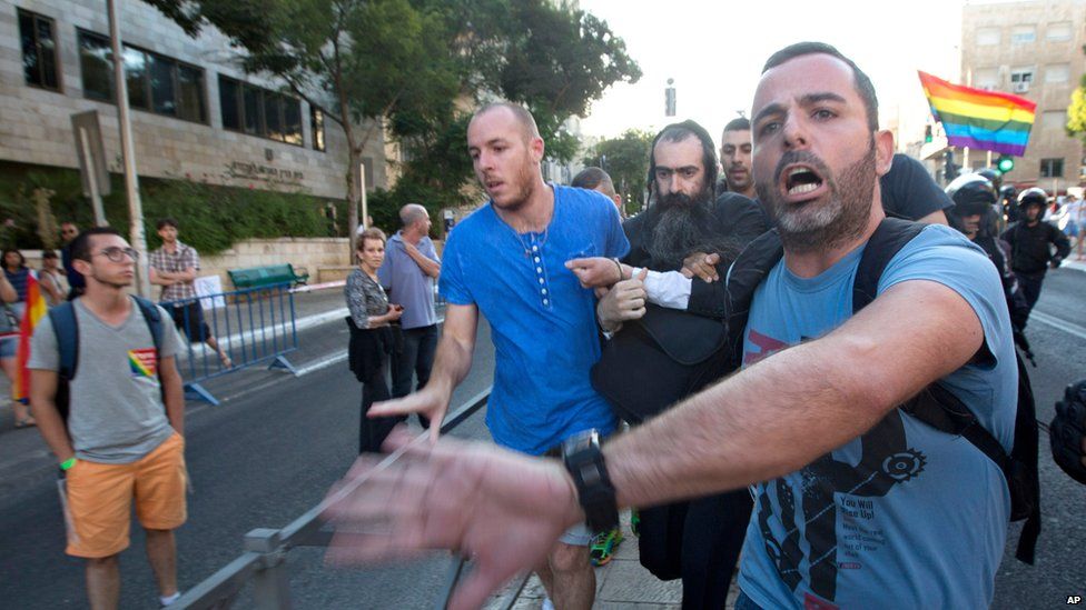 Plainclothes Israeli police detain an-ultra Orthodox Jew after he attacked people with a knife during a Gay Pride parade Thursday, July 30, 2015
