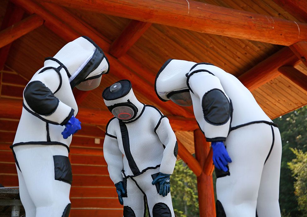 Participants attending an Asian giant hornet field training day look at their protective suits at Birch Bay State Park, Washington, US, on 18 August 2021