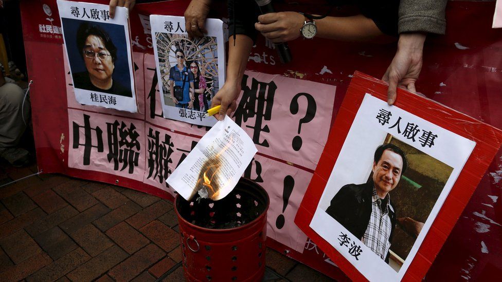 A pro-democracy demonstrator burns a letter next to pictures of missing staff members of a publishing house and a bookstore, including Gui Minhai, a China-born Swedish national who is the owner of Mighty Current, Cheung Jiping, the business manager of the publishing house and Causeway Bay Books shareholder Lee Bo (L-R), during a protest to call for an investigation behind their disappearance, outside the Chinese liaison office in Hong Kong, China January 3, 2016