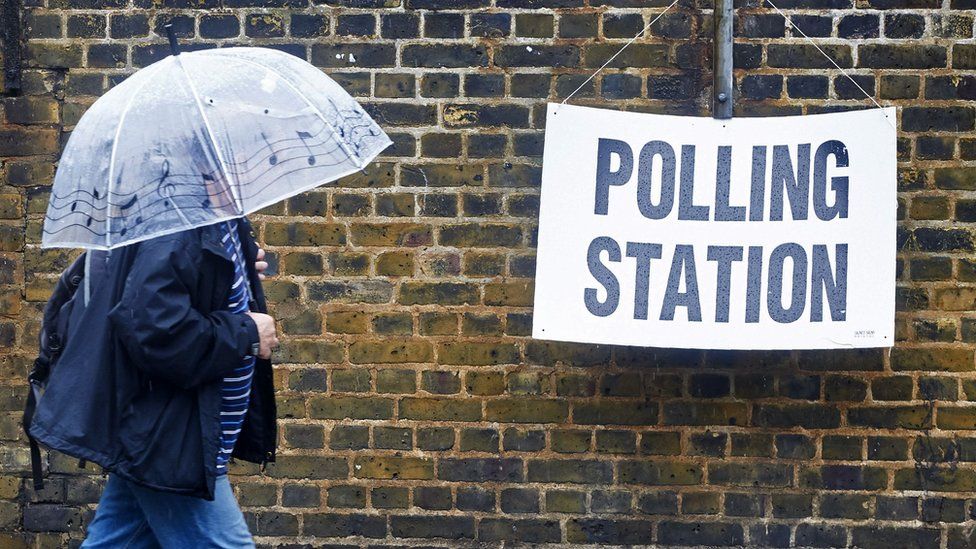 Man under umbrella at polling station