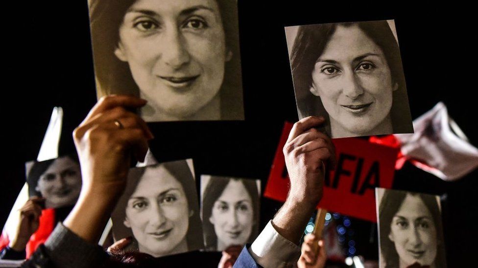 People holding placards reading "Mafia government" and photos of killed journalist Daphne Caruana Galizia, stage a protest on 29 November, 2019