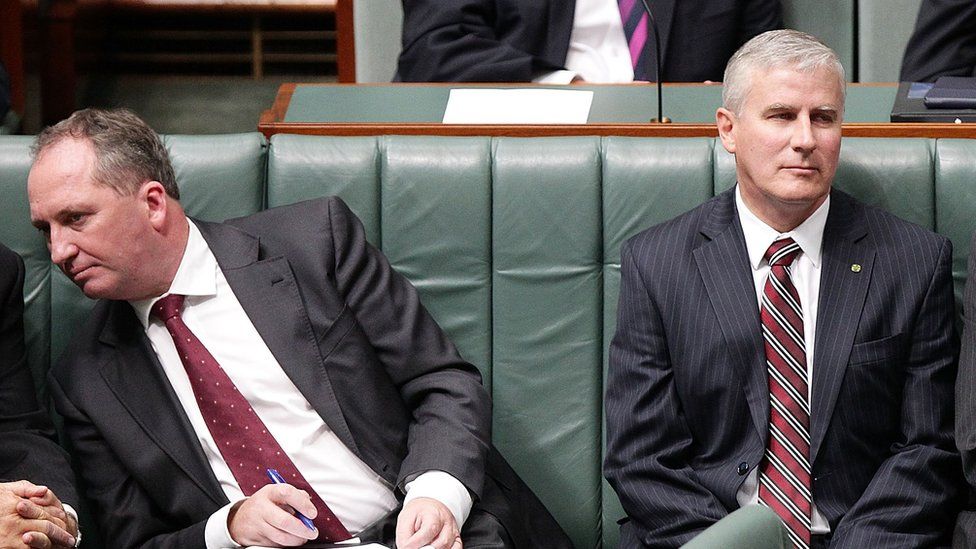 Barnaby Joyce leans away from Michael McCormack in parliament