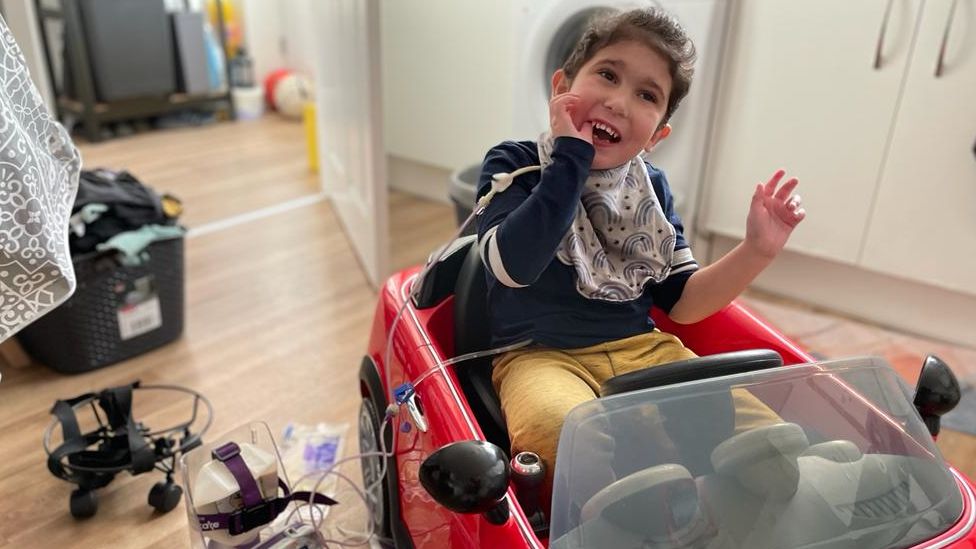 Cohen in his kitchen in a toy car