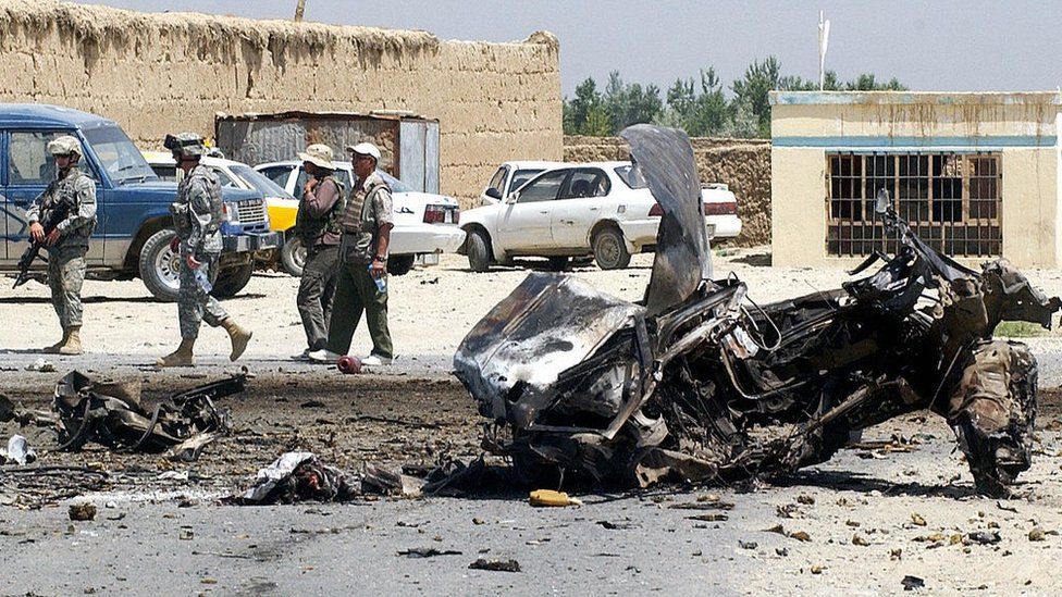 Американские солдаты охраняют место теракта, совершенного террористом-смертником, недалеко от главной базы США в Афганистане в Баграме 26 июня 2006 года.