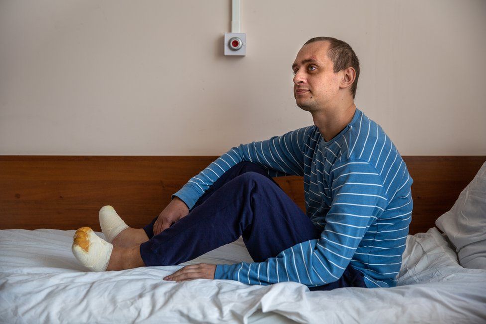 Nikita Horban sits on his hospital bed in Kyiv. He has begun to take a few steps.