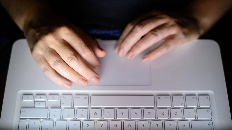 Anonymous hands typing on a laptop