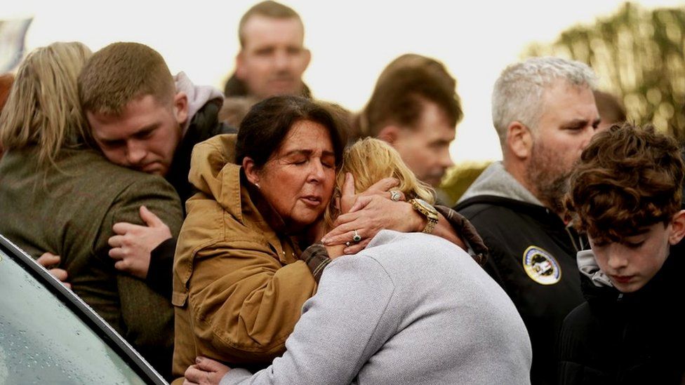 People hug each other at a vigil in Milford in County Donegal
