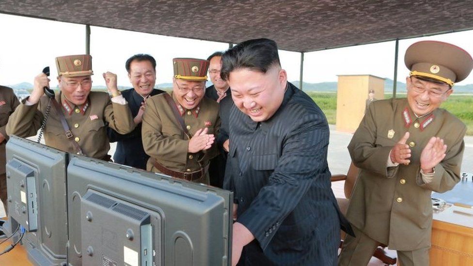 Kim Jong-un (second right) and North Korea's top military and political leaders celebrate the latest launch