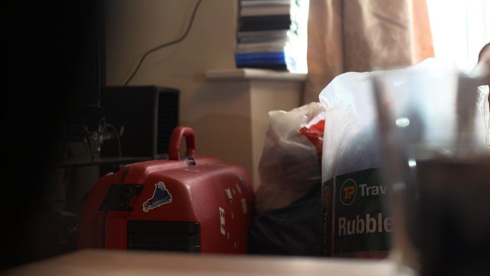 Red suitcase and plastic bags on personal possessions