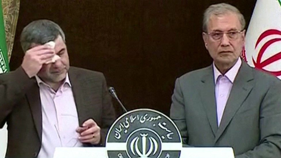 Iranian Deputy Health Minister Iraj Harirchi (L) mops his brow during a news conference on 24 February 2020