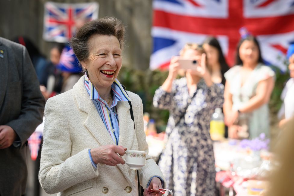Princess Anne speaks (L) with residents of a street as they hold a Coronation street party on May 07, 2023 in Swindon, England