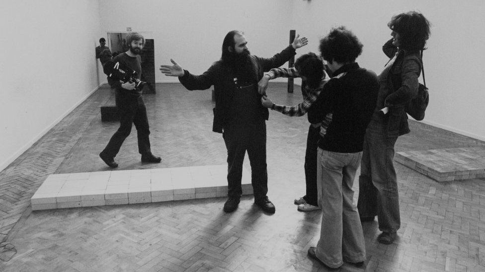 Carl Andre with his controversial "pile of bricks" sculpture at London's Tate gallery in 1976