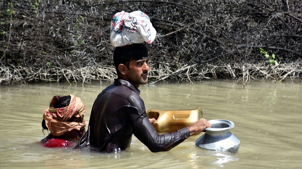 People affected by floods move on to higher grounds in Balochistan province, Pakistan.