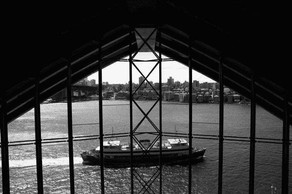 A ferry passes by windows of the Sydney Opera House