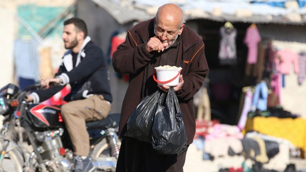 A man eats food distributed as aid in a besieged rebel-held area of Aleppo, Syria (6 November 2016)