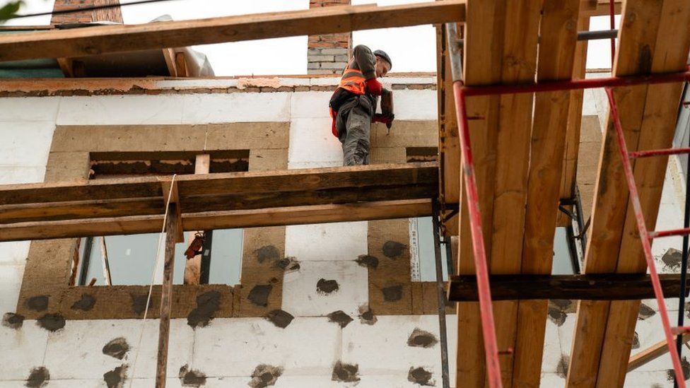 Work is under way on rebuilding a badly damaged Soviet apartment block in Bucha