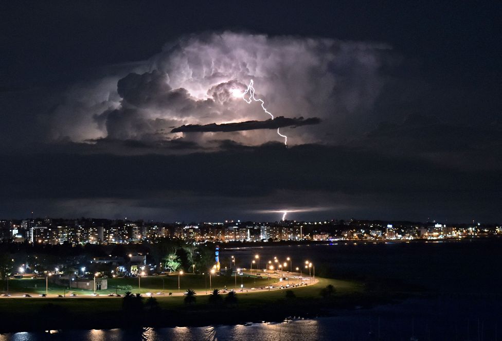 A lightning bolt illuminates clouds during a thunderstorm in Montevideo, Uruguay, on 26 April 2022