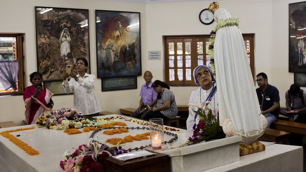 People gather around the tomb of Mother Teresa inside the Mother house in Kolkata, India, Saturday, September 3