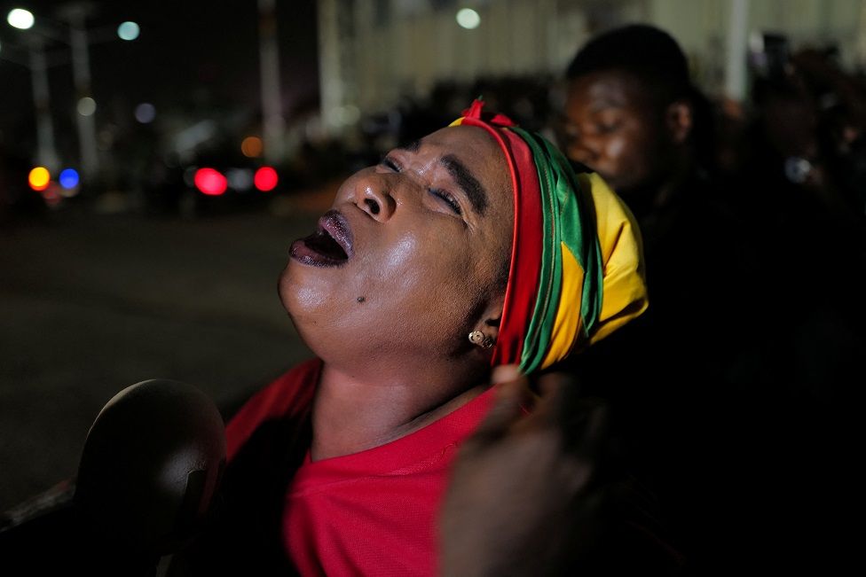 A mourner reacts as the body of late Ghanaian soccer player, Christian Atsu Twasam, 31, who died in the earthquake in Turkey, arrives at the Kotoka International Airport in Accra, Ghana, February 19, 2023.