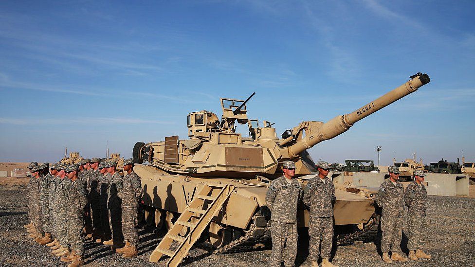 US soldiers stand at attention at a military base in Kuwait.