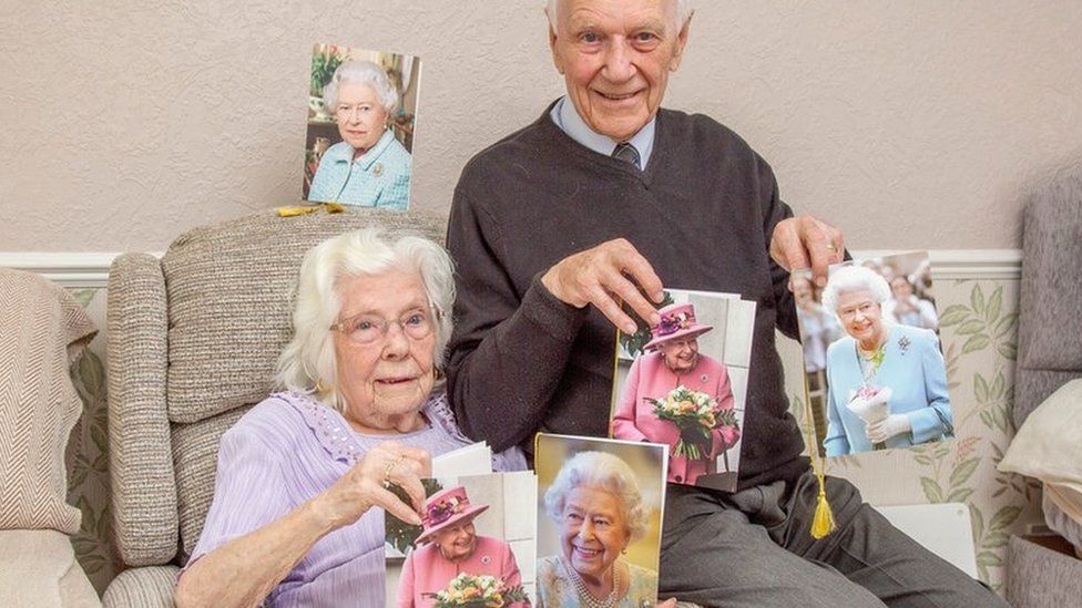 Ivy and John Winn hold pictures of the Queen