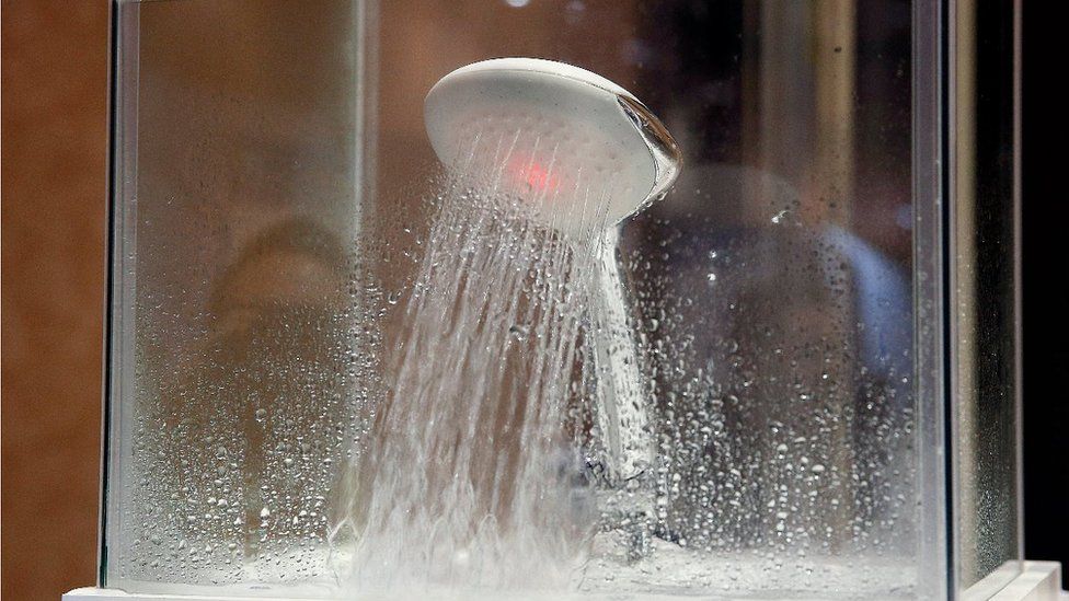 A showerhead with a red light illuminated inside