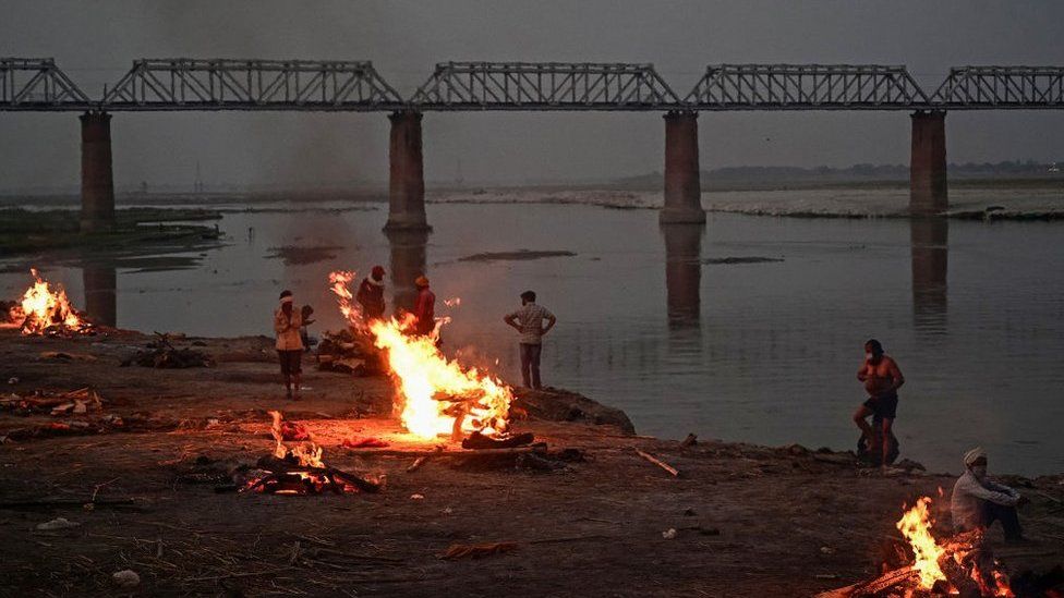 Funeral pyres are lit by the Ganges in Allahabad - bodies have been washing up downstream for days