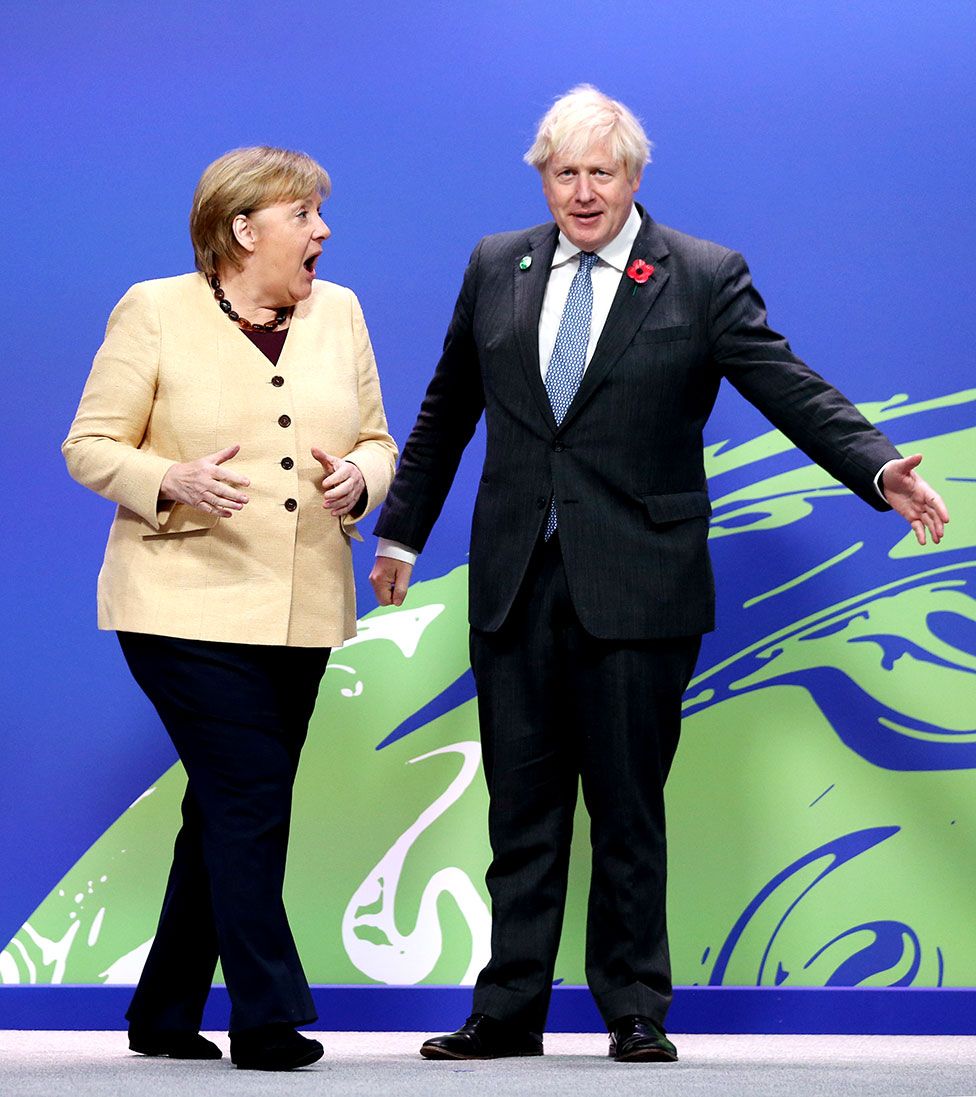 Prime Minister Boris Johnson (right) greets German Chancellor Angela Merkel at the COP26 UN Climate Change Conference in Glasgow, 1 November 2021.