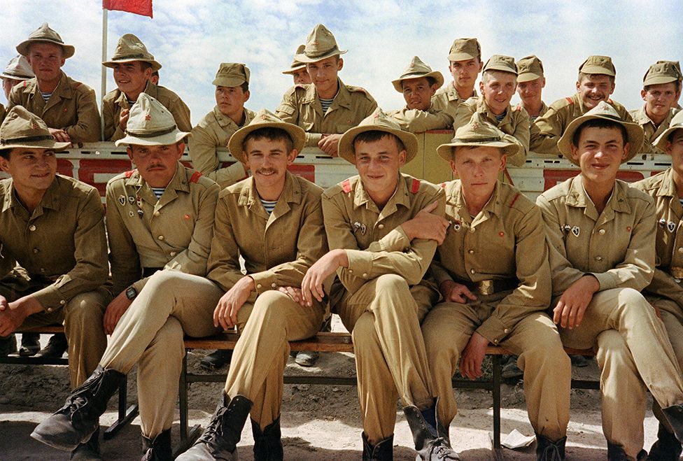 A Red Army soldiers smile 16 August 1988 during a parade as Soviet Army troops stop in Kabul prior to their withdrawal from Afghanistan. The Soviet Union invaded Afghanistan in December 1979 to shore up the pro-Soviet regime in Kabul and maintained more than 100,000 troops in the country until completing their phased withdrawal in 1989.