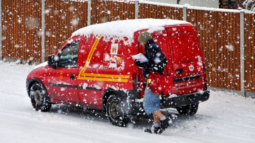 A Royal Mail postal worker in the snow