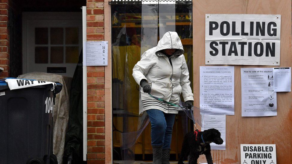 Voter leaves polling station in Croydon with her dog