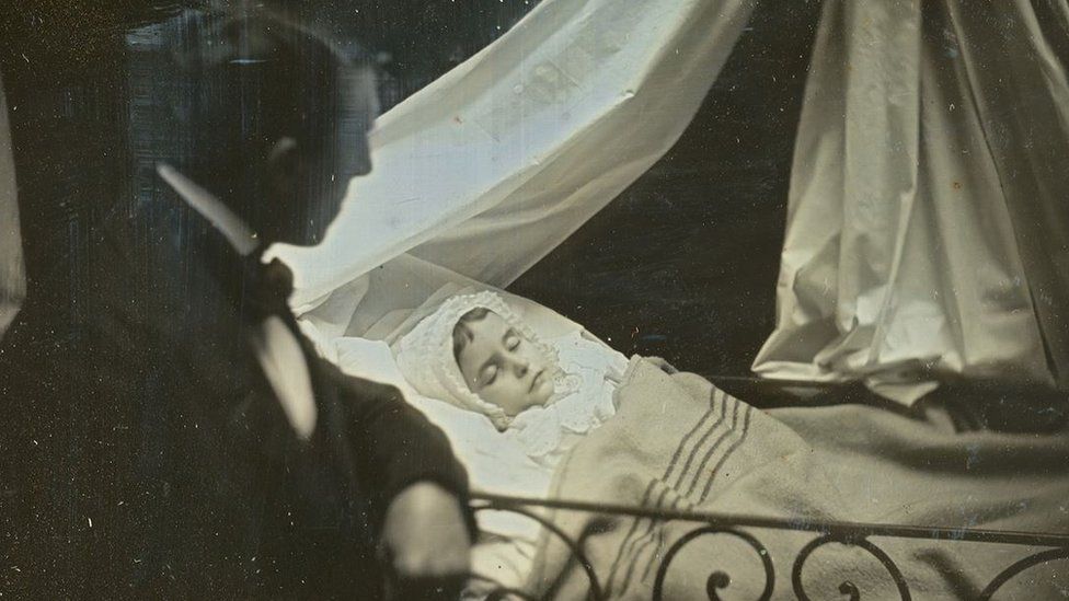 A man looking at the dead body of a woman