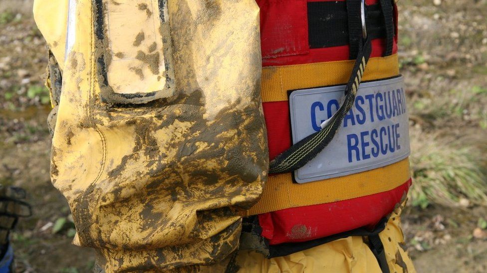 Coastguard rescuer with mud on uniform