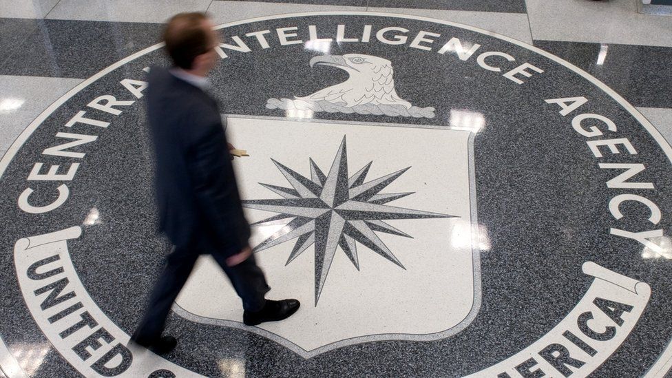 A man crosses the Central Intelligence Agency (CIA) logo in the lobby of CIA Headquarters in Langley, Virginia