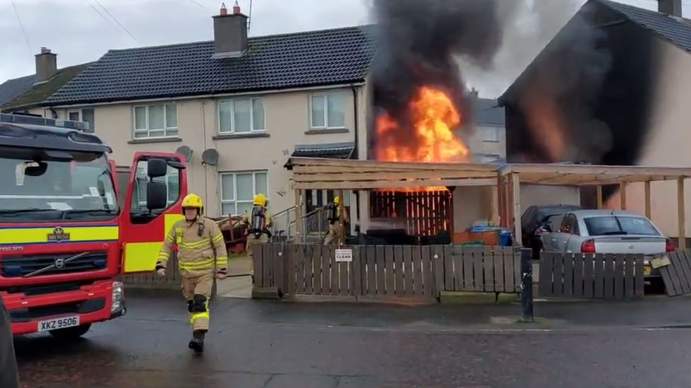 Fire engine extinguishing a shed fire