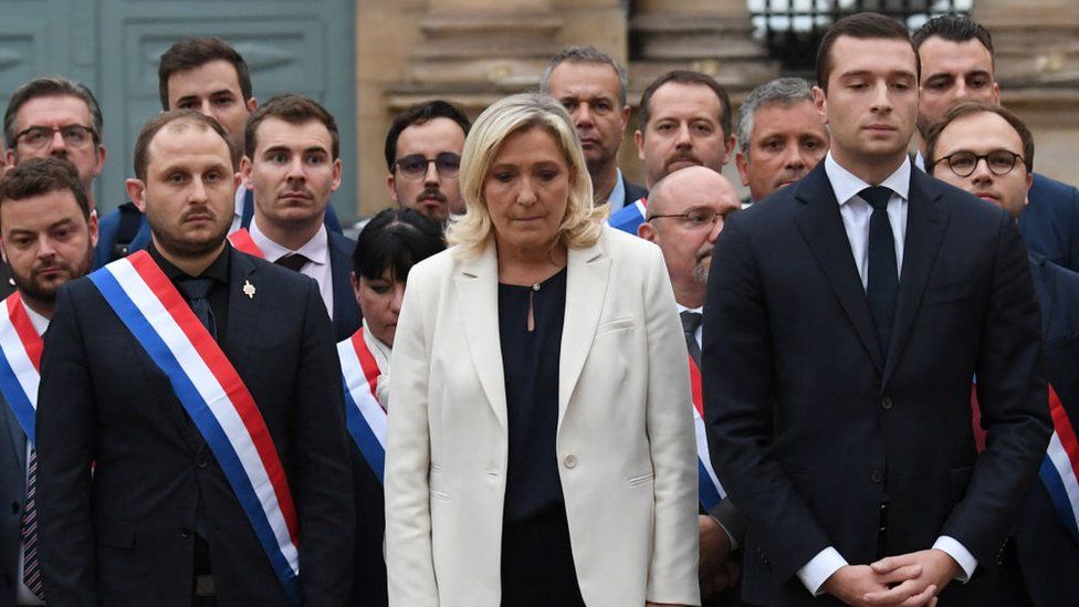 Марин Ле Пен (в центре) и ее крайне правая партия «Национальное объединение» проводят минуту молчания у здания французского парламента Лола