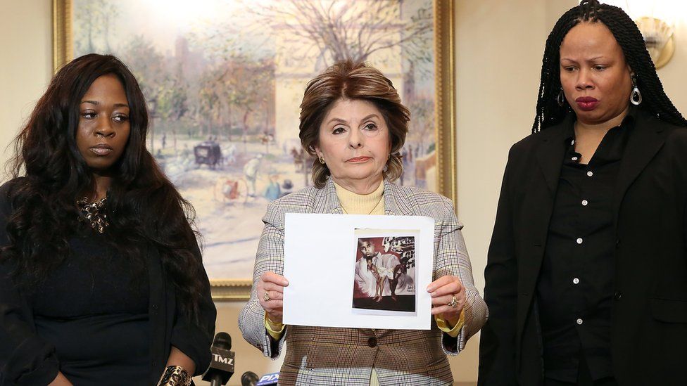 Rochelle Washington (l), lawyer Gloria Allred and Latresa Scaff display photos taken on the night of the alleged abuse by R Kelly at Lotte New York Palace on February 21, 2019