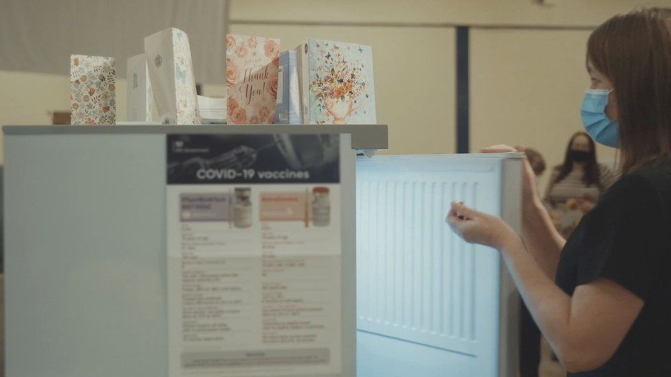 Nurse getting vaccine doses from the fridge in government advert, "Every vaccination gives us hope"