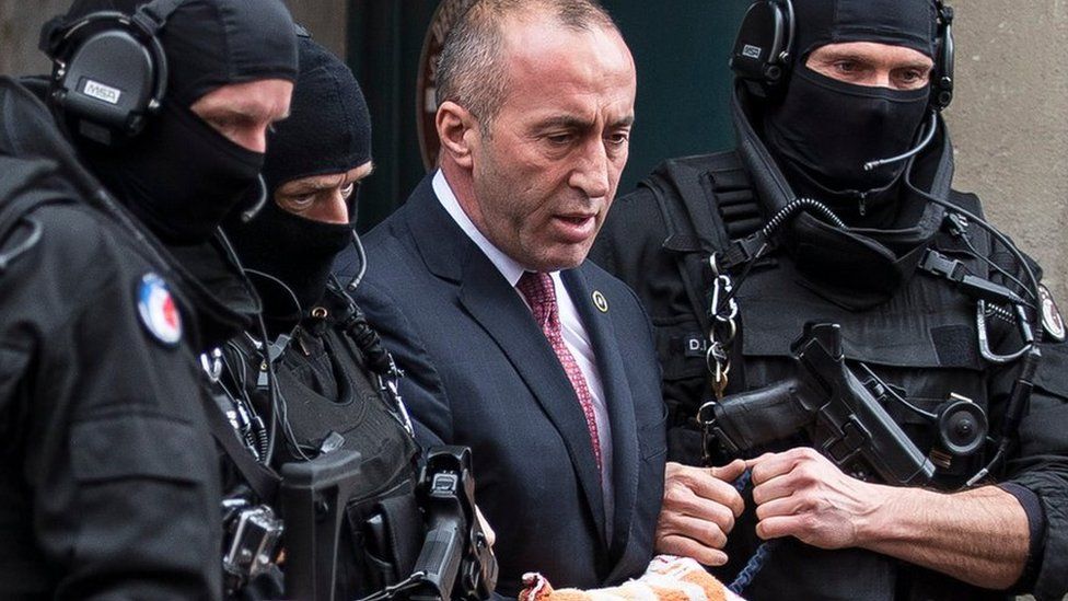 Former prime minister of Kosovo Ramush Haradinaj, center, leaves the court escorted by hooded police officers in Colmar, eastern France