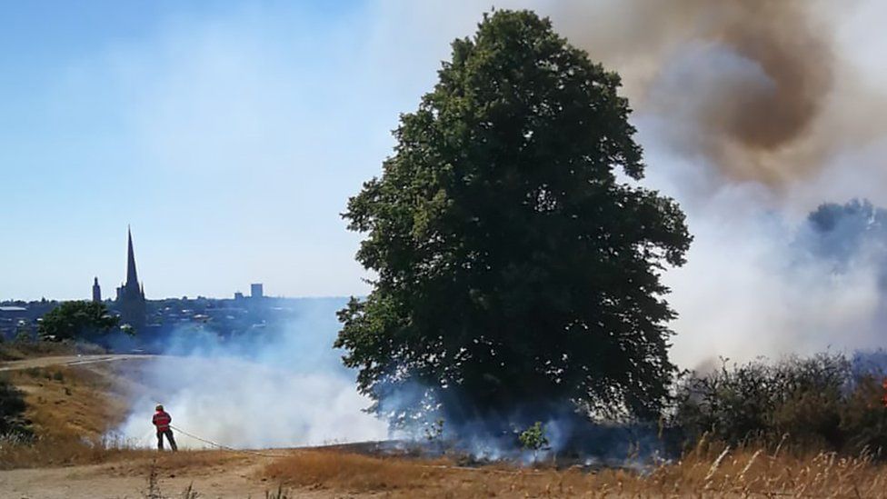 Fire and smoke on Mousehold Heath in Norwich with Norwich Cathedral seen in the distance