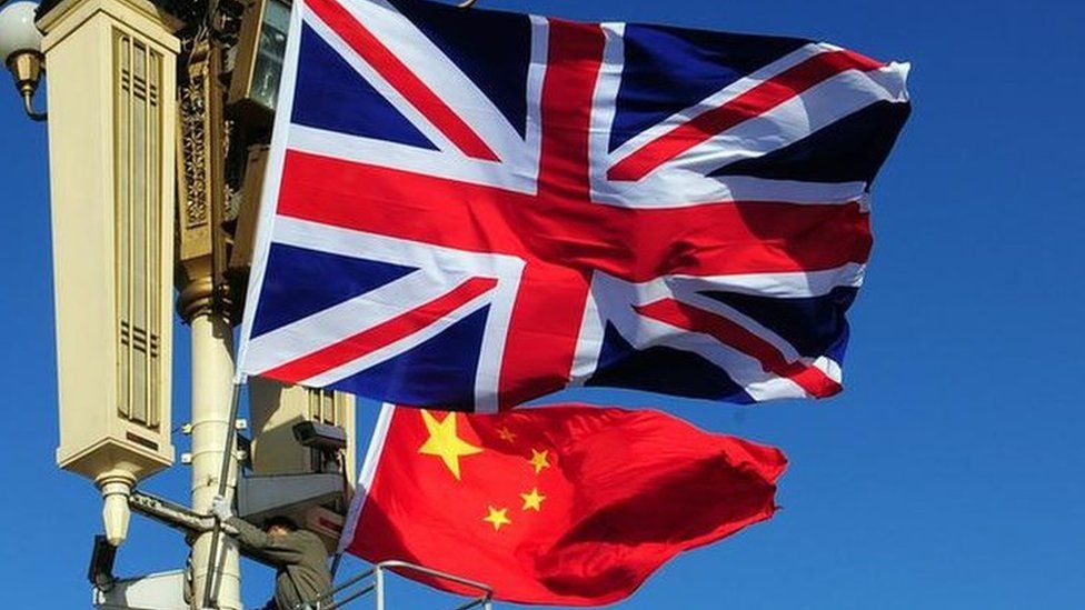 Union Jack flag is hoisted next to the flag of the Peoples Republic of China in front of Tiananmen Gate