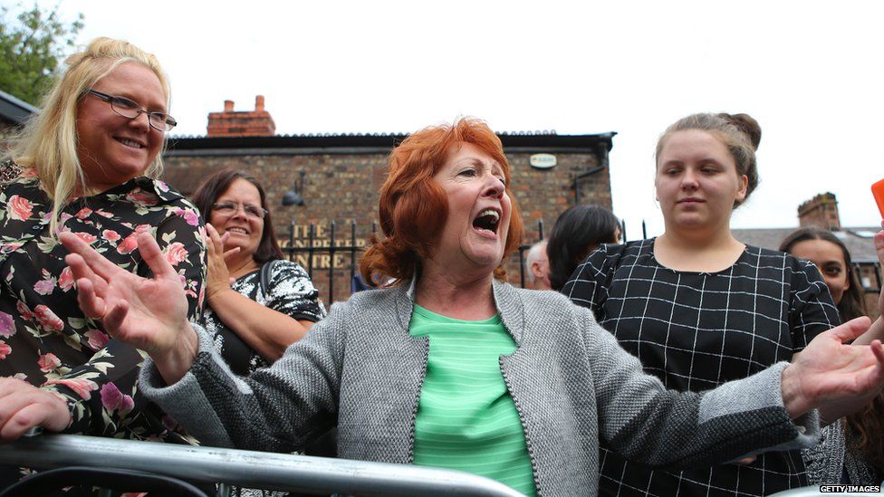 A Cilla Black tribute singer entertains members of the public outside the church