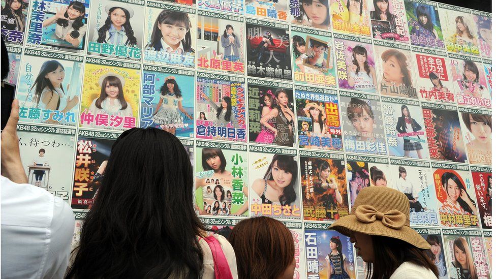 Japanese girls pop group AKB48 fans look at the election campaign posters prior to the group's general election announcement at the Yokohama stadium in Yokohama, south of Tokyo on 8 June 2013.