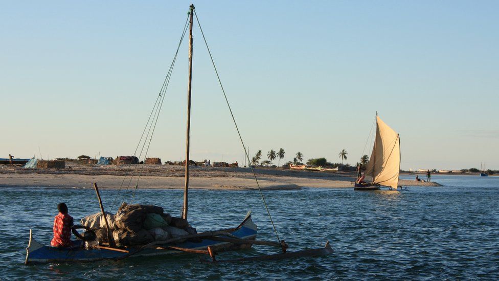 A man sails from Belo-sur-mer on a boat laden with cargo