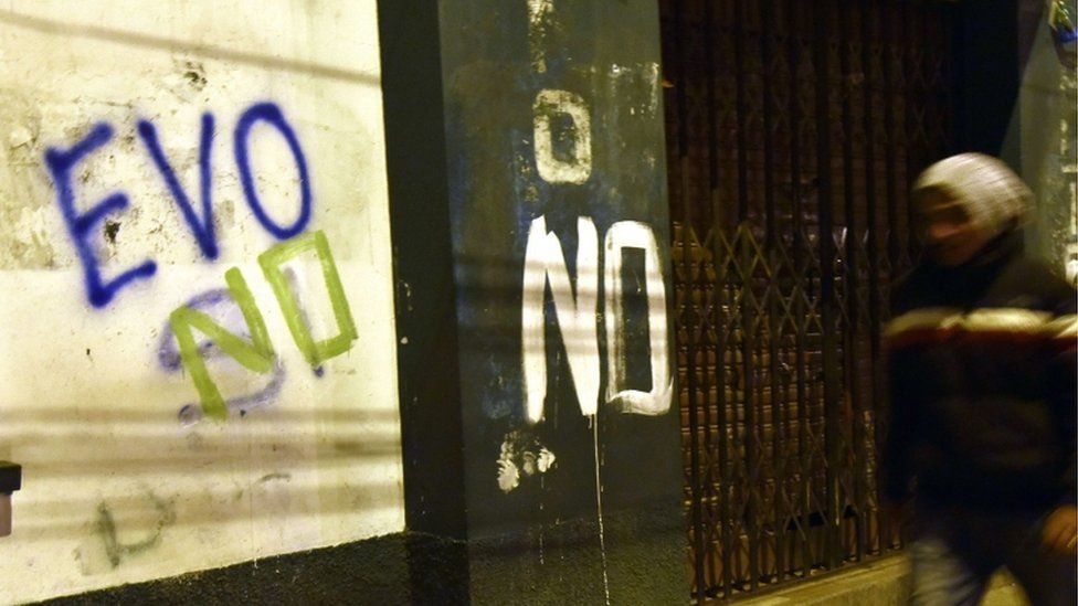 A man is seen walking next to a graffiti that reads "Evo no" after the referendum in El Alto, Bolivia, on 21 February 2016