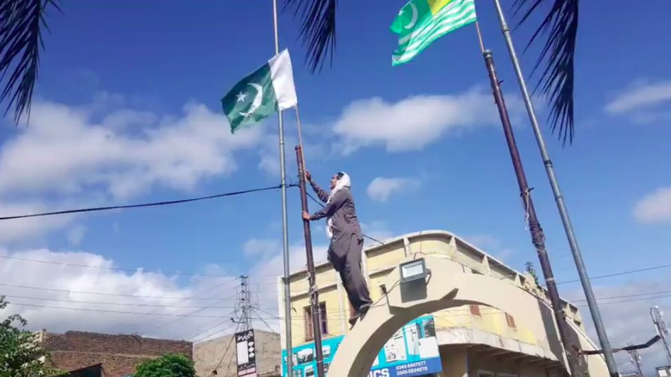 Tanveer Ahmed Rafique pictured removing the Pakistani flag, which led to his arrest